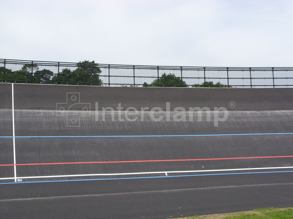 Velodrome safety barrier built with dark green Interclamp key clamp DDA fittings, providing a strong and visually appealing protective boundary.